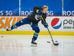 Canucks defenceman Jack Rathbone does the traditional solo warm-up skate without a helmet before his first NHL regular-season game in May, 2021.