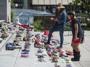 Two hundred-and-fifteen pairs of kids shoes line the steps of the Vancouver Art Gallery Friday, May 28, 2021 in response to the revelation that 215 children's remains were discovered this week at the site of the former Kamloops residential school.