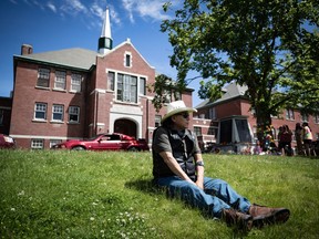 Kamloops Indian Residential School survivor Clayton Peters, 64, who was forced into the school for 10 years, sits on the lawn at the former school, near where the remains of 215 children have been discovered.