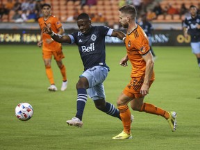 Vancouver Whitecaps FC forward Cristian Dajome (11) and Houston Dynamo FC defender Adam Lundqvist (3) battle for the ball during the first half at BBVA Stadium.