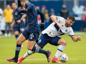 Vancouver Whitecaps forward Lucas Cavallini (9) struggles for control of the ball around Sporting Kansas City midfielder Ilie Sanchez (6) during the first half in front of the goal at Children's Mercy Park.