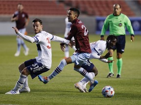 Vancouver Whitecaps midfielder Russell Teibert (31) and midfielder Janio Bikel (19) take out Colorado Rapids midfielder Younes Namli (21) in the first half at Rio Tinto Stadium last Sunday. The foul led to the Rapids' only goal, as Diego Rubio's top-corner free kick wunder goal was the difference in the 1-0 loss.