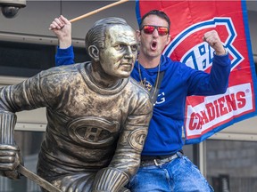 Habs fan Eric Boucher hams it up on the Howie Morenz statue at the Bell Centre in Montreal on Saturday June 19, 2021.