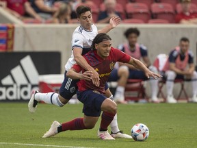 Marcelo Silva of Real Salt Lake is tackled by Brian White of the Vancouver Whitecaps FC during their game June 18, 2021 at Rio Tinto Stadium in Sandy, Utah.