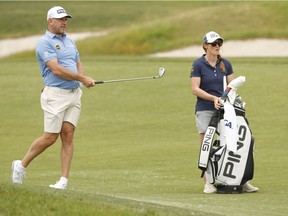 Lee Westwood of England plays a shot on the fifth hole as caddie and wife Helen Storey looks on at Torrey Pines Golf Course on June 14, 2021 in San Diego, California.