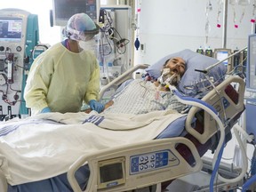 ICU nurse Manjot Kaur cares for COVID-19 patient Joseph Trudeau, 49, in the ICU at Surrey Memorial Hospital Friday.