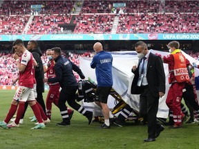 Paramedics using a stretcher to take out of the pitch Denmark's Christian Eriksen after he collapsed during the Euro 2020 soccer championship group B match between Denmark and Finland at Parken stadium in Copenhagen, Denmark, Saturday, June 12, 2021.
