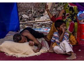 A Rohingya refugee family rests in a temporary shelter after a fire destroyed a Rohingya refugee camp in New Delhi, India, on June 14, 2021.