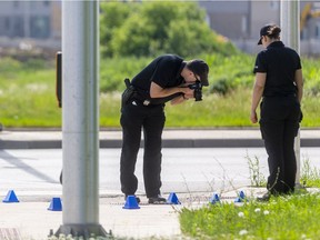 Forensic officers take evidence photos at the scene of the multiple fatality in London, Ont.