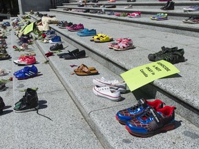 Two hundred-and-fifteen pairs of kids shoes line the steps of the Vancouver Art Gallery Friday, May 28, 2021 in response to the revelation that 215 children's remains were discovered this week at the site of the former Kamloops residential school.