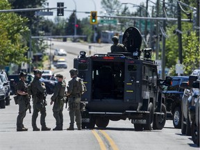 RCMP ERT members gather around an armoured vehicle on Westminster Highway between Gilley Road and McLean Avenue in Richmond on June 22, 2021.
