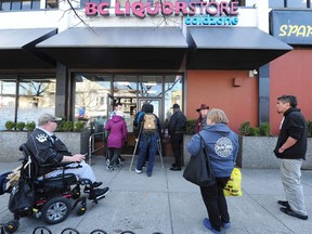 Customers lined up before opening time at the B.C. Liquor Store on Commercial Drive in Vancouver on March 19, 2020.
