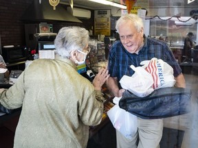 Coney Market owner Richard Ravenscroft chats with customers as he leaves with a delivery order.