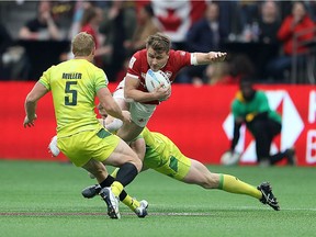 Lachie Miller #5 and Henry Hutchison #1 of Australia tackle Theo Sauder #1 of Canada during their rugby sevens semi final at B.C. Place on March 8, 2020 in Vancouver.