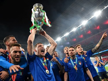 LONDON, ENGLAND - JULY 11: (L-R) Leonardo Spinazzola, Rafael Toloi, Andrea Belotti and Jorginho of Italy celebrate with The Henri Delaunay Trophy following their team's victory in the UEFA Euro 2020 Championship Final between Italy and England at Wembley Stadium on July 11, 2021 in London, England.