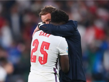 Bukayo Saka of England is consoled by Gareth Southgate, Head Coach of England following defeat in the UEFA Euro 2020 Championship Final between Italy and England at Wembley Stadium on July 11, 2021 in London, England.