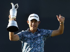 British Open champion Collin Morikawa of United States hoists the Claret Jug on the 18th hole at Royal St George’s Golf Club in Sandwich, England, on July 18, 2021.