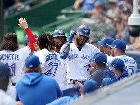 Lourdes Gurriel Jr. of the Toronto Blue Jays celebrates with teammates after hitting a grand slam home run in the first inning of the second game of a doubleheader against the Texas Rangers at Sahlen Field in Buffalo, N.Y., on July 18, 2021.