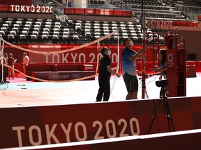 Officials prepare a volleyball net at the Ariake Arena ahead of the Tokyo 2020 Olympic Games on July 19, 2021 in Tokyo, Japan.