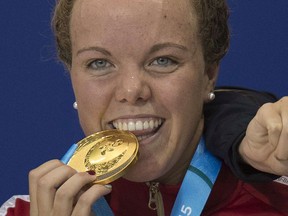 Gold medallist Kierra Smith of Kelowna bites her medal after competing in the women's 200 metre breaststroke at the 2015 Pan American Games in Toronto on July 15.