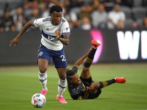 Vancouver Whitecaps defender Javain Brown (23) takes the ball down field away from Los Angeles FC forward Raheem Edwards (44) in the first half at Banc of California Stadium.