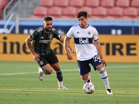 L.A. Galaxy defender Derrick Williams chases Vancouver Whitecaps forward Brian White during first-half action at Rio Tinto Stadium in Sandy, Utah, Saturday.