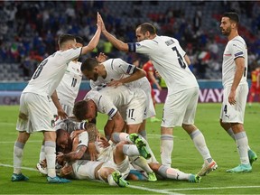 Italy's midfielder Nicolo Barella celebrates with teammates after scoring the team's first goal during the UEFA EURO 2020 quarter-final football match between Belgium and Italy at the Allianz Arena in Munich on July 2, 2021.