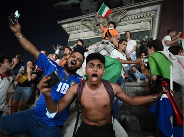 Supporters of the Italian national football team celebrate after Italy beat England 3-2 on penalties to win the UEFA EURO 2020 final football match between England and Italy in Piazza del Duomo in Milan on July 11, 2021.