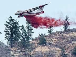 A Conair airtanker drops fire retardant on part of the Nk'Mip Creek wildfire near Osoyoos, British Columbia, Canada July 20, 2021. Picture taken July 20, 2021. Mike Fitzpatrick/Handout via REUTERS. NO RESALES. NO ARCHIVES. THIS IMAGE HAS BEEN SUPPLIED BY A THIRD PARTY. MANDATORY CREDIT