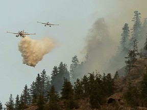 Water bombers designed to scoop water from nearby lakes douse part of the Nk'Mip Creek wildfire near Osoyoos.