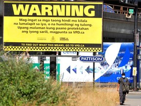 A VPD billboard near Rogers Arena that had been vandalized with anti-police graffiti, in Vancouver on July 26. The billboard reads in part: “Warning. Be cautious of strangers getting close or asking for help.”