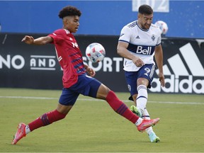 FC Dallas defender Justin Che (32) defends against Vancouver Whitecaps forward Lucas Cavallini (9) in the first half at Toyota Stadium.