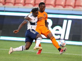 Vancouver Whitecaps midfielder Janio Bikel (19) and Houston Dynamo defender Teenage Hadebe (18)  at Rio Tinto Stadium.