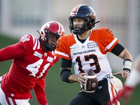 B.C. Lions quarterback Michael Reilly runs the ball as Calgary Stampeders' Mike Rose closes in during first half CFL football action in Calgary Thursday, Aug. 12, 2021.