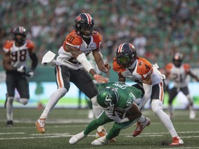 Lions defenders Garry Peters (left) and Bo Lokombo wrap up Roughriders receiver Shaq Evans after he gathers in the ball during the previous game that the teams faced each other, a 33-29 Riders win that opened both teams’ CFL season in Regina on Aug. 6.