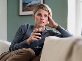 A woman with a glass of wine indoors at home.