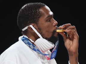 Kevin Durant of Team United States bites his gold medal during the medal ceremony for Men's Basketball at the Tokyo 2020 Olympic Games at Saitama Super Arena on Aug. 7, 2021 in Saitama, Japan.