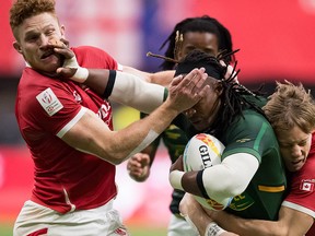 Canada's Connor Braid, left, and Harry Jones, right, tackle South Africa's Branco du Preez during the bronze medal match at the Canada Sevens rugby tournament in Vancouver March 8, 2020. The event is expected to return this fall.