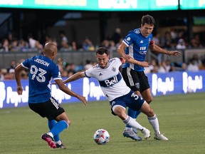 Vancouver Whitecaps midfielder Russell Teibert fights for control of the ball against San Jose Earthquakes midfielder Judson (left) and defender Tanner Beason during the first half at PayPal Park.