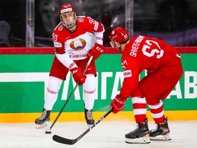 Belarus’s Danila Klimovich controls the puck under pressure from ROC’s Artyom Shvets-Rogovoi in preliminary round action at the 2021 IIHF Ice Hockey World Championship at Olympic Sports Centre on June 1, 2021 in Riga, Latvia.