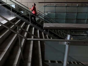 A person in a face mask rides an escalator in an otherwise empty pedestrian mall during the outbreak of the COVID-19 in the Downtown area of Manhattan, New York City, Aug. 9, 2021.