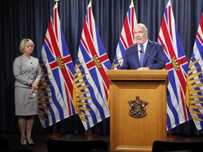 Provincial Health Officer Dr. Bonnie Henry looks on as Premier John Horgan speaks about the COVID-19 vaccine card set to arrive in mid-September as they discuss details about the process during a press conference at provincial legislature in Victoria, Monday, Aug. 23, 2021.
