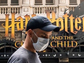 A man wears a mask to prevent against the spread of coronavirus disease (COVID-19) while he walks around Theater District in Times Square, as the highly transmissible Delta variant has led to a surge in infections, in New York City, U.S., July 30, 2021.