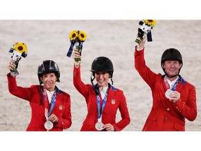 Silver medallists Laura Kraut of the United States, Jessica Springsteen of the United States and McLain Ward of the United States celebrate a silver medal in equestrian show jumping.