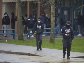Students wearing masks leave Queen Elizabeth Secondary school in Surrey in February.