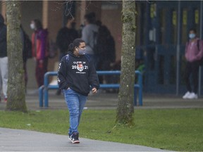 Students wearing masks leave Queen Elizabeth Secondary school in Surrey earlier this year.