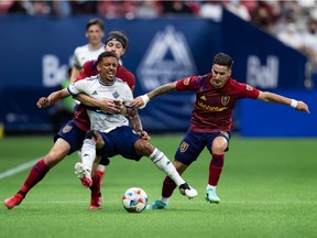 Vancouver Whitecaps' Bruno Gaspar, front left, is grabbed by Real Salt Lake's Nick Besler, back left, as he and Jonathan Menendez, right, vie for the ball during first-half MLS soccer action at B.C. Place Stadium last week.