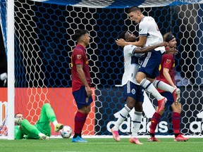 Vancouver Whitecaps' Ranko Veselinovic, front right, and Ranko Veselinovic celebrate after a Real Salt Lake own goal against goalkeeper Andrew Putna, back left, during first half MLS soccer action in Vancouver on Sunday.