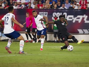 Alphonso Davies (No. 19) of Canada crosses the ball to set up a Canada goal against the United States during the second half of a World Cup qualifying match at Nissan Stadium on September 5, 2021 in Nashville, Tennessee.