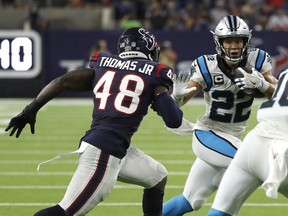 Christian McCaffrey #22 of the Carolina Panthers tries to get around the tackle of Joe Thomas #48 of the Houston Texans during a first half run at NRG Stadium on September 23, 2021 in Houston, Texas.